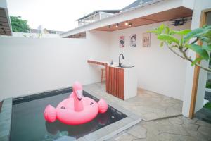an inflatable pink elephant in a pool in a house at Among Villa Demangan in Yogyakarta