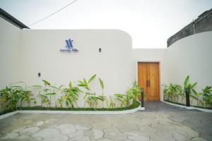 a white building with plants on the wall at Among Villa Demangan in Yogyakarta