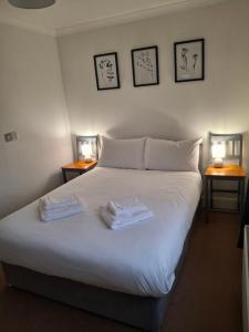 a bedroom with a bed with two towels on it at The Cabin in Carbis Bay