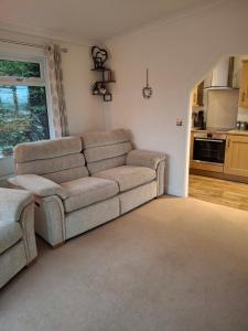 a living room with a couch and a kitchen at The Cabin in Carbis Bay +19 photos