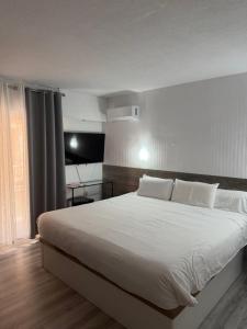 a bedroom with a large bed with white sheets at Hotel Carlos III in Águilas