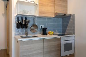 a small kitchen with a sink and blue tiles at Hoeve Koning Willem III in Frederiksoord +9 photos