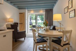 a kitchen and living room with a table and chairs at Hoeve Koning Willem III in Frederiksoord