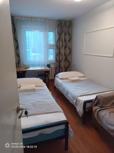 a room with three beds and a window at Tsogoo Guesthouse Shared rooms in Ulaanbaatar