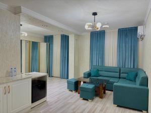 a living room with a blue couch and a table at Toshkent Hotel in Andijan