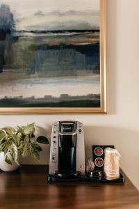a coffee maker sitting on top of a wooden table at Aurora Inn in Kingston