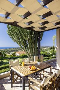 a wooden table with a bowl of fruit on a patio at Kefalonian Oneira Villas in Mousata