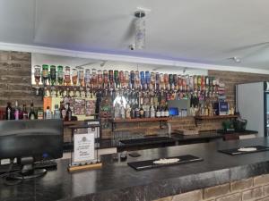 a bar with a lot of bottles on the wall at Lodge Linga Longa in Queenstown