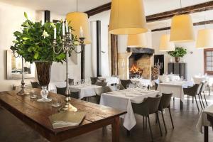 a restaurant with white tables and chairs and a fireplace at Château Les Merles et ses Villas in Mouleydier