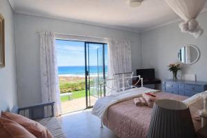 a bedroom with a bed with a view of the ocean at 14 Penguin Place, Melkbosstrand in Melkbosstrand