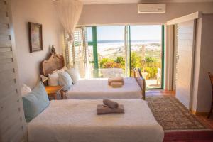 a hotel room with two beds and a view of the ocean at 14 Penguin Place, Melkbosstrand in Melkbosstrand