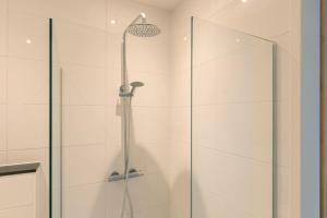 a shower with a glass door in a bathroom at Hoeve Koning Willem III in Frederiksoord