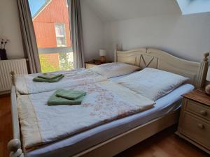 a bedroom with a bed with two green towels on it at Ferienhaus am Yachthafen in Greifswald