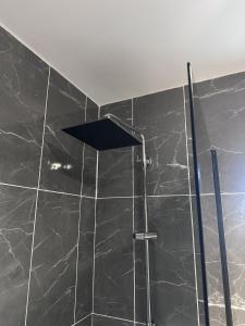 a shower with a black tiled wall and a ceiling at New Haven Atherton Greater Manchester in Atherton +8 photos