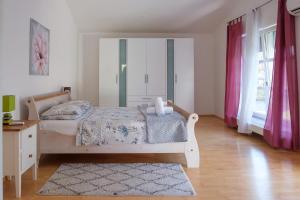 a bedroom with a bed and a dresser and windows at Villa Vinko in Donje Raštane +25 photos