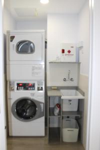 a kitchen with a washing machine and a sink at Albergue Linares in Santiago de Compostela