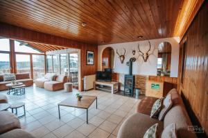 a living room with a couch and a table at Le Gagnage 31 pers- Malmedy, rustique, vue, wellness in Malmedy