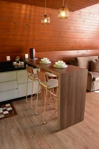 a kitchen with a wooden table and chairs at Cabanas Lago - Piratuba-SC in Piratuba