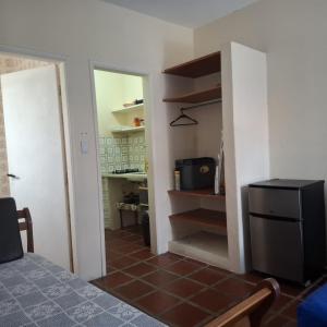 a room with a kitchen and a room with a bed at Kitnets a 200 m da praia in Peruíbe