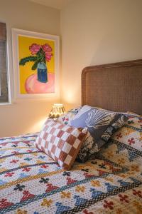 a bed with a quilt with a flower in a vase at Costers Lodge in Midhurst +3 photos