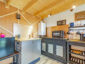 a large kitchen with wooden walls and wooden ceilings at Holly's Hidden Hideaway - Uk36783 in Sutton Valence