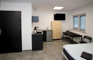 a room with a bed and a table and a kitchen at Mia Mia House in Katowice