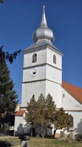 a white tower with a steeple on top of a building at Cosy apart 3 Fagaras in Făgăraş
