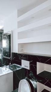 a bathroom with a toilet and a sink and a mirror at Cosy apart 3 Fagaras in Făgăraş
