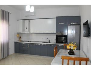 a kitchen with blue cabinets and a table with flowers at Diar Sea House in Orikum +8 photos