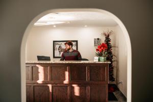 a man sitting at a counter in a room at Aurora Inn in Kingston