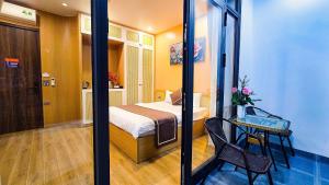 a bedroom with a bed and a table with a chair at Ha Anh Villa Ninh Binh in Ninh Binh