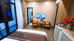 a hospital room with a bed and a table and chairs at Ha Anh Villa Ninh Binh in Ninh Binh