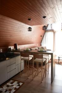 a kitchen with a table and chairs in a room at Cabanas Lago - Piratuba-SC in Piratuba