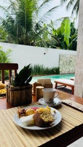 a plate of food and a cup of coffee on a table at Vila Marina Icaraizinho in Icaraí