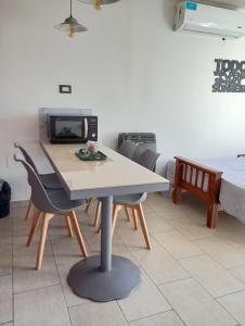 a table and chairs in a room with a microwave at Las ruinas 1 in Carhué