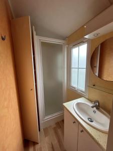 a bathroom with a sink and a mirror and a window at Camping Le Pavillon bleu in L'Aiguillon-la-Presqu'île +31 photos