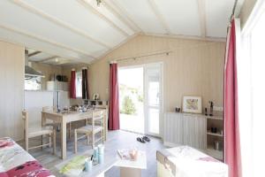 a living room with a table and a kitchen at Camping Le Pavillon bleu in L'Aiguillon-la-Presqu'île
