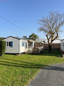 a white house with a tree in the yard at Camping Le Pavillon bleu in L'Aiguillon-la-Presqu'île