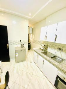 a white kitchen with white cabinets and a sink at New dream home in Fez +10 photos
