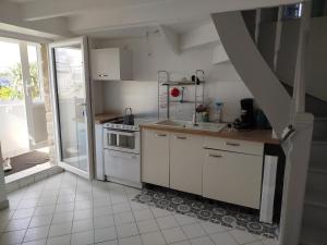 a small kitchen with a sink and a stove at Maison à L'île Grande in Pleumeur-Bodou