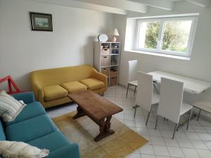 a living room with a couch and a table at Maison à L'île Grande in Pleumeur-Bodou
