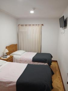 a hotel room with two beds and a window at Residencial Encontro in Vila Real