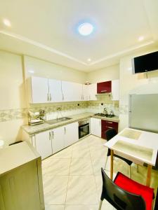 a kitchen with white cabinets and a table and chairs at New dream home in Fez
