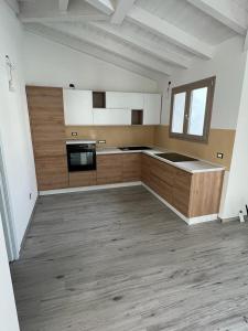 a large kitchen with wooden cabinets and appliances in a room at Villetta Maluva - Budoni in Budoni +12 photos