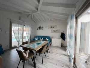 a dining room with a table and chairs and a bedroom at Villetta Maluva - Budoni in Budoni