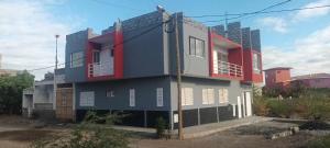 a building with red and blue paint on it at Chez Fortes in Porto Novo