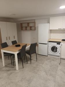a kitchen with a table and chairs in a kitchen at Kawalerka Perzycka in Poznań +5 photos