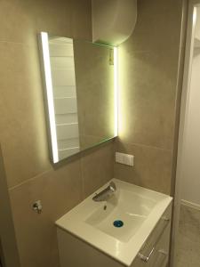 a bathroom with a sink and a mirror at Kawalerka Perzycka in Poznań