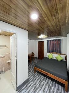 a bedroom with a bed with a wooden ceiling at Natalie's Homestay Bed and Breakfast in El Nido