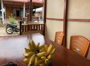 a bunch of bananas sitting on top of a wooden table at Heiner Beach Homestay in Bunaken